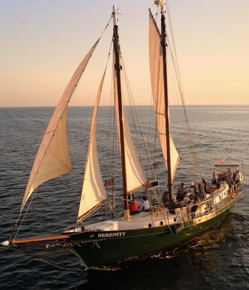 Aerial view of the schooner Serenity under sail with people on deck