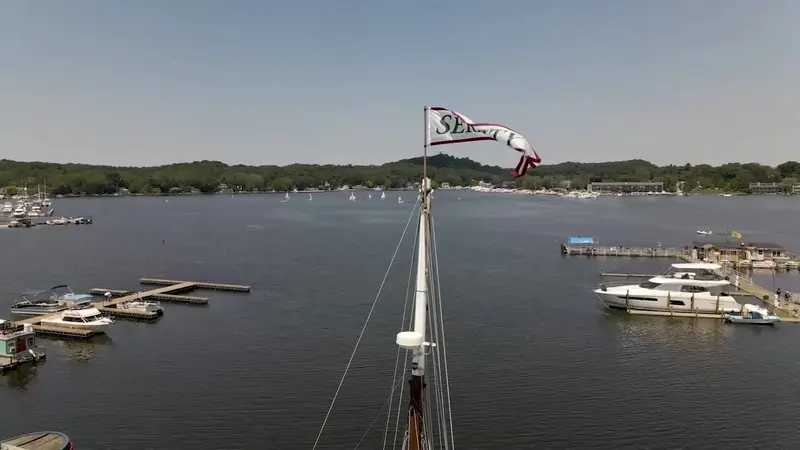 Serenity’s masthead and pennant high above a harbor of docks and moored boats